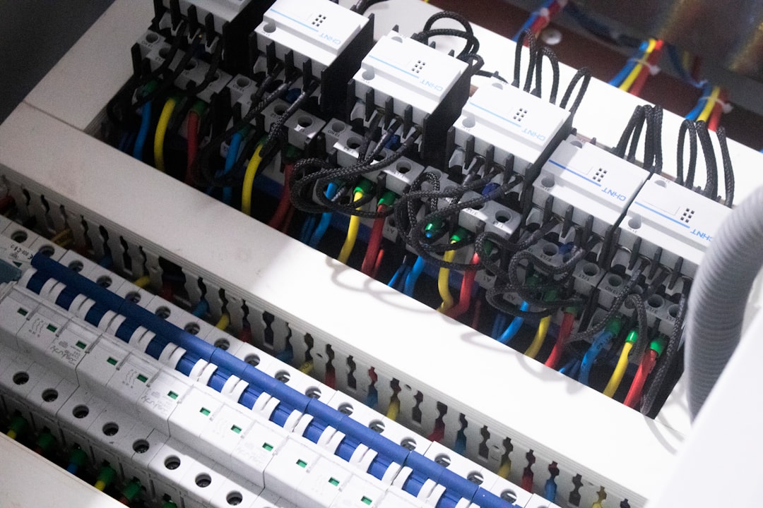 Detailní pohled do otevřeného elektrického rozvaděče s kabely a jističi
